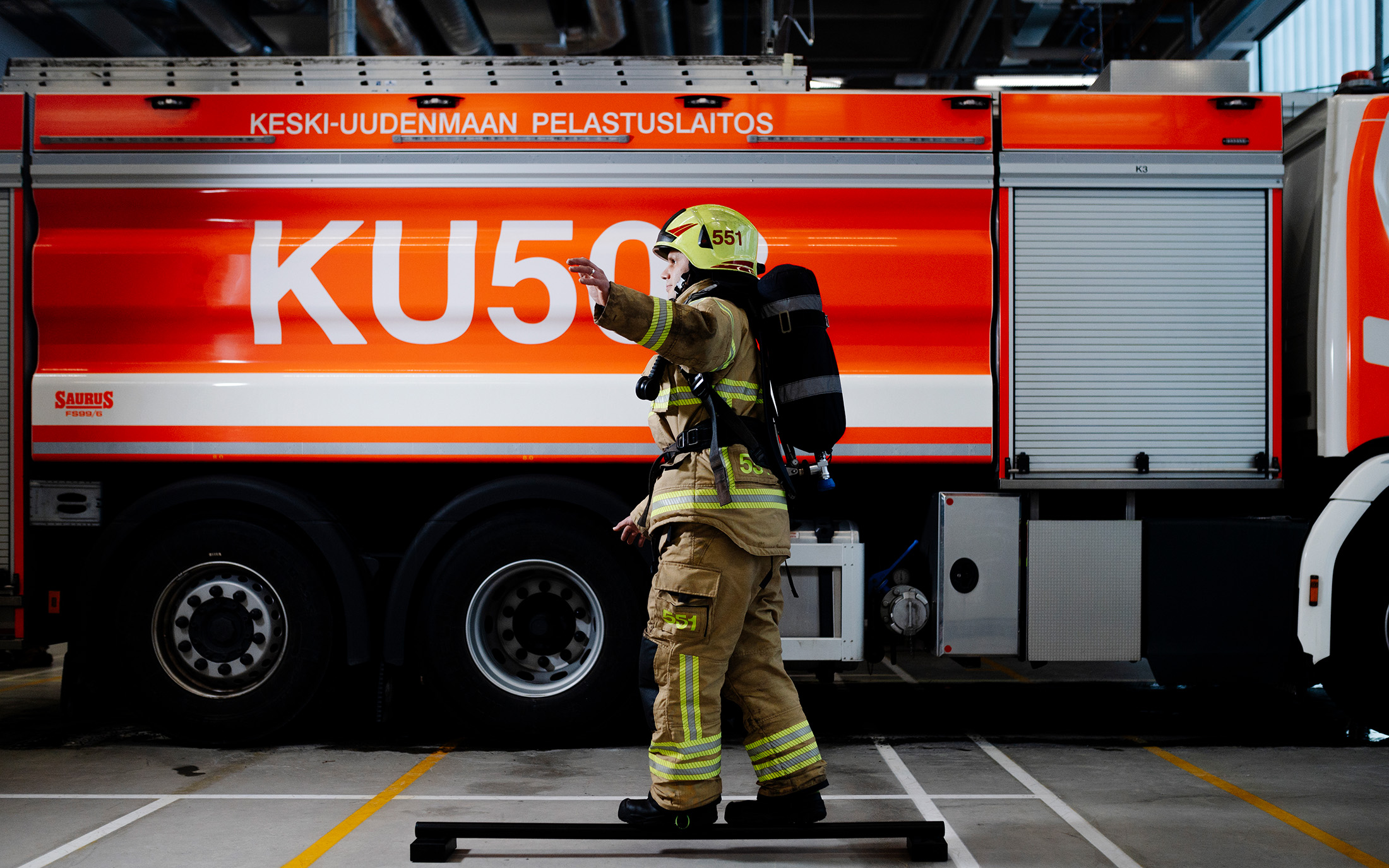 Palomies Ilkka Lähdesmäki tekee tasapainoharjoituksia kalustohallissa Kerava-Tuusulan paloasemalla.