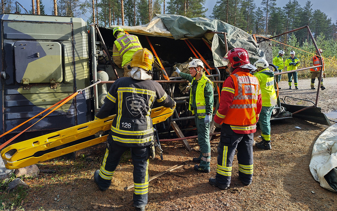Pelastajia tieliikenneonnettomuuden harjoituksessa, kuvassa kaatunut ajoneuvo.