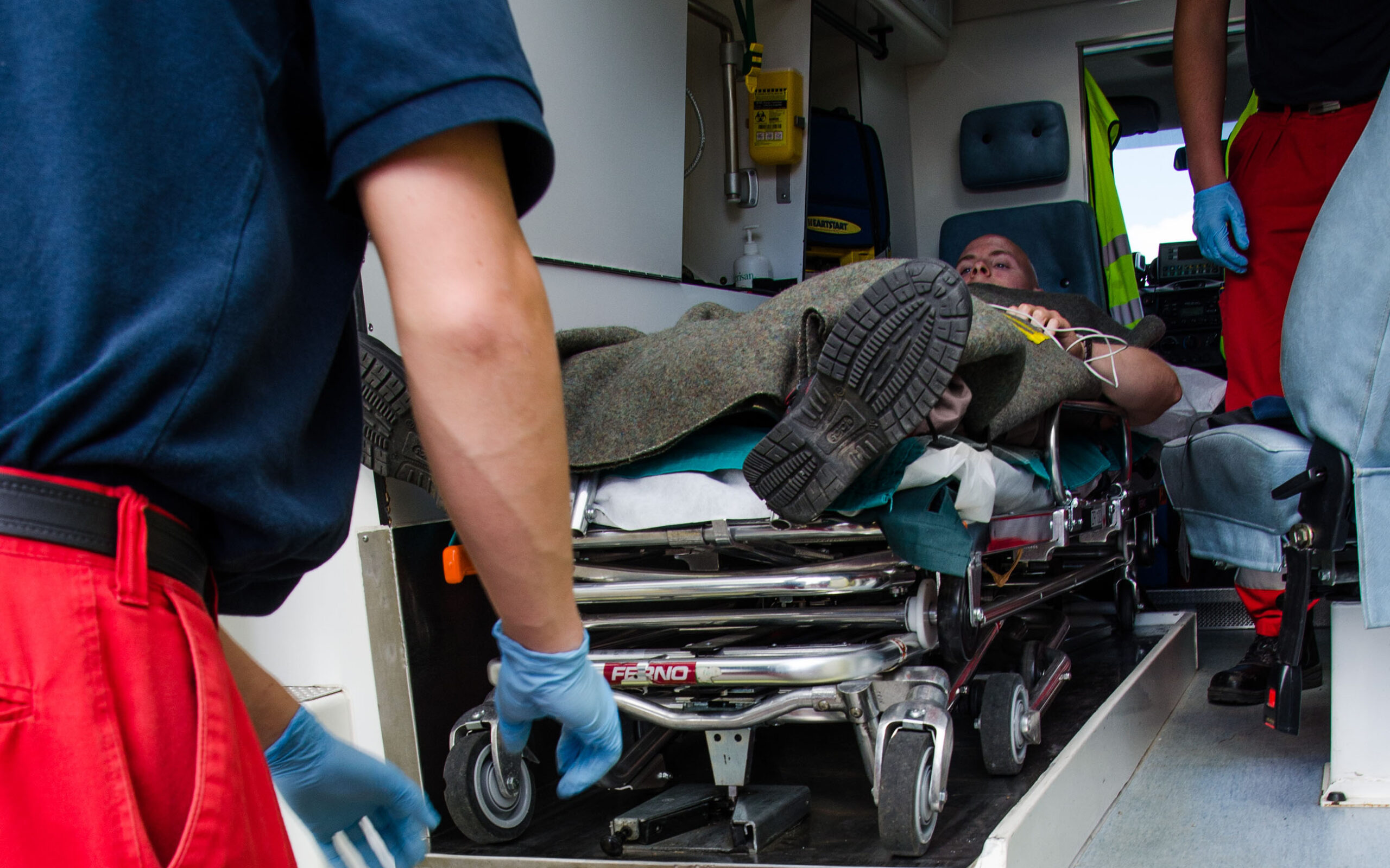 Ensihoitajat siirtämässä potilasta ambulanssiin.