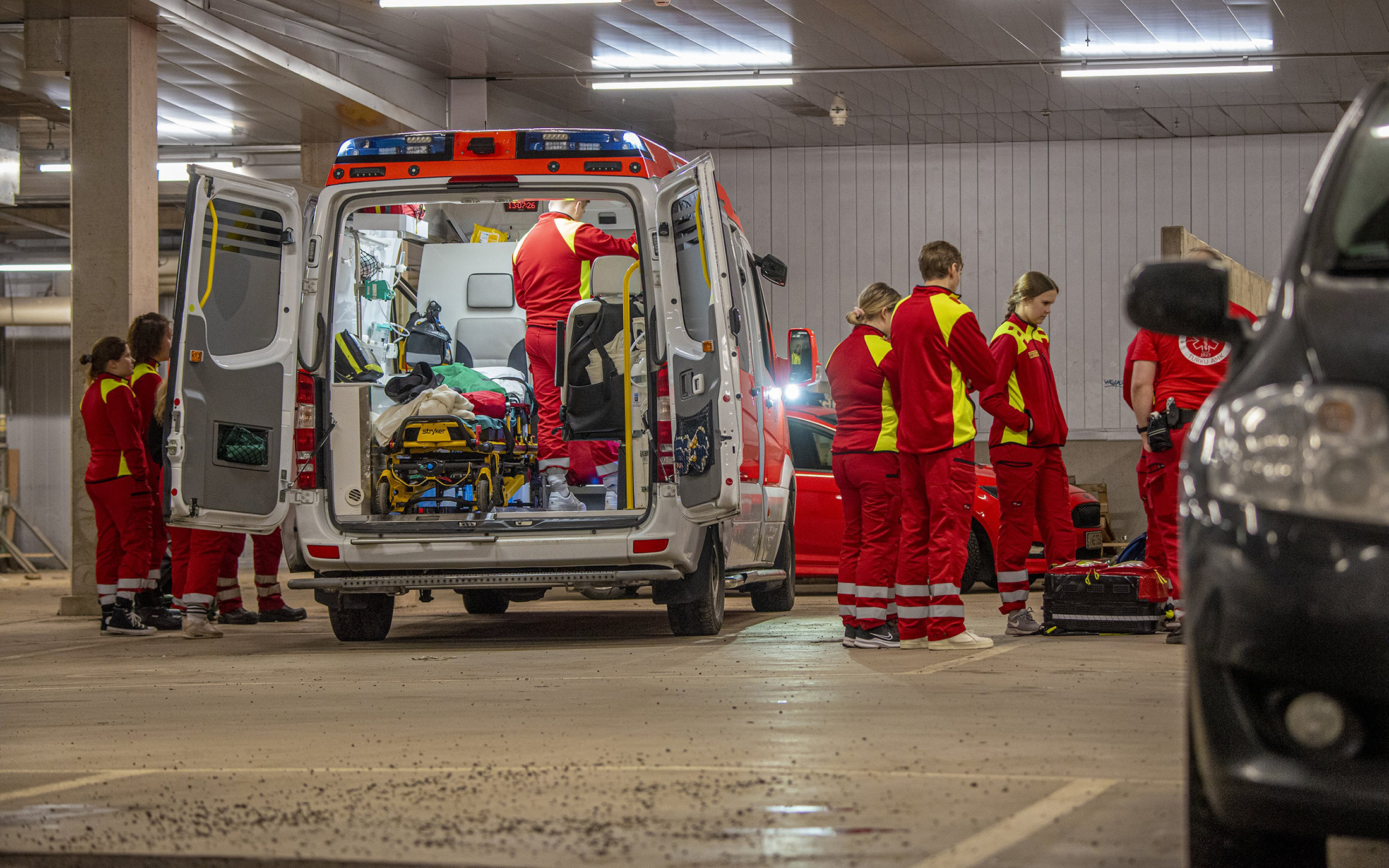 Ensihoitajia ambulanssissa ja sen vierellä koulutustilaisuudessa